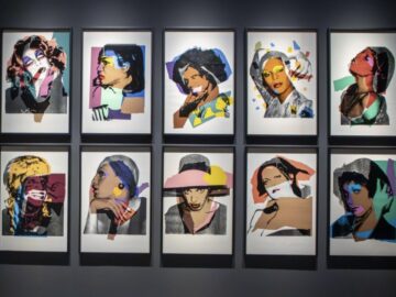 Il legame tra Andy Warhol e Ferrara affonda le radici nel secolo scorso, in un’Italia ancora artisticamente e politicamente polarizzata. Era l’ottobre del 1975 quando Palazzo dei Diamanti aprì le porte a una delle prime grandi retrospettive italiane dedicate al genio di Pittsburgh, evento che rappresentò un vero e proprio shock culturale e che consacrò la città come un centro d’avanguardia internazionale.  Oggi quel dialogo sospeso nel tempo si riaccende, nella medesima sede capolavoro dell’architetto Biagio Rossetti, con la mostra <Andy Warhol - Ladies and Gentlemen>, aperta al pubblico fino al 19 luglio 2026. Attraversarne le sale per assaporare questo nuovo appuntamento, significa ritrovare intatta l’energia dirompente di quella prima esposizione, ma con una prospettiva attuale, capace di spingersi ben oltre la semplice celebrazione della Pop Art.  Tutto l’universo di Warhol nasce dal mondo dei consumi, come la grafica pubblicitaria, il packaging e le illustrazioni commerciali, che lui ha trasformato in un vero e proprio linguaggio d’arte. Nei primi anni Sessanta prende gli oggetti più rappresentativi della tradizione capitalista americana, quali lattine di zuppa Campbell’s, bottiglie di Coca-Cola e fumetti, e inizia a riprodurli all’infinito con la serigrafia. Non si tratta di un semplice espediente visivo, ma di un’operazione quasi industriale che toglie unicità all’immagine e, paradossalmente, la carica di una nuova, violenta forza.  Con questa stessa logica nascono sia le raffigurazioni dei divi hollywoodiani e delle celebrità che frequentavano la Factory newyorkese – da Marilyn Monroe a Mick Jagger – sia i ritratti della serie “Ladies and Gentlemen”, progetto con il quale Warhol accende i riflettori sulle drag queen e sulle donne trans afroamericane e portoricane della New York degli anni Settanta. Figure, all’epoca, del tutto escluse dai media tradizionali e da un mercato dell’arte profondamente bianco ed eteronormativo. È proprio nello scarto sulla scelta dei soggetti da immortalare che l’”iconizzazione” pop di Warhol smette di essere un espediente puramente commerciale e si trasforma in un mezzo per portare alla luce i conflitti legati all’identità, sfidare le dinamiche di potere e restituire finalmente spazio e memoria a chi era stato condannato all’invisibilità sociale.  L’esposizione in corso ripropone, quale nucleo centrale e spunto per una lucida riflessione politica, i ritratti della serie “Ladies and Gentlemen”, accompagnati da capolavori dagli anni Sessanta agli Ottanta, che tracciano una mappa delle ossessioni di Warhol. Ci sono i ritratti di Mick Jagger, Liza Minnelli, Robert Mapplethorpe e Grace Jones, disposti accanto alla celebre immagine di Mao Tse-tung – ridipinto e truccato fino a diventare un’icona glamour svuotata di qualsiasi significato ideologico -, individui impegnati, così come le Ladies e i Gentlemen, nella costante messa in scena del proprio sé. Una galleria di corpi fatti per essere guardati, “riletti” come merce filtrata dalla dinamica della riproducibilità infinita.  Il percorso espositivo affianca a queste grandi tele le Polaroid originali dell’artista, un vero e proprio contro-archivio visivo che registrava i volti ignorati dai canoni della fotografia ufficiale. Dal confronto tra la fragilità immediata degli scatti privati e la monumentalità della serigrafia emerge la complessità dell’operazione artistica compiuta da Warhol che, nella folla di celebrità, analizza anche sé stesso. Gli autoritratti esposti nascono come un ulteriore esperimento sul rapporto tra il soggetto e la sua immagine, una specie di archeologia del selfie contemporaneo, in cui l’artista si mette sullo stesso piano delle star che dipinge, diventando cavia di un sistema mediatico che non controlla più fino in fondo. La sua faccia diventa un’interfaccia vulnerabile, dove la parrucca argentea, il trucco e le luci costruiscono un personaggio che non coincide mai del tutto con l’uomo in carne e ossa, ma che resta l’unico modo che abbiamo per conoscerlo.  È qui che la mostra trova la sua vera forza: nel rifiuto di nascondere l’ambiguità profonda di Warhol. Sala dopo sala, l’allestimento fa accumulare domande al visitatore, mentre restituisce un autore da sempre in bilico tra il ruolo di complice e quello di critico spietato di un ingranaggio che fagocita ogni cosa per trasformarla in puro intrattenimento, compresa la vulnerabilità delle persone.  Si esce da Palazzo dei Diamanti con una sensazione difficile da definire. Warhol, in fondo, ci restituisce un mondo in cui l’identità è continuamente costruita, filtrata, rimessa in scena. Un mondo che, a distanza di decenni, somiglia fin troppo al nostro.